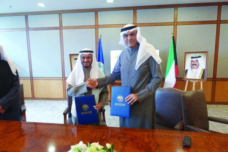 البرجس مصافحاً المطيري عقب توقيع بروتوكول التعاون 