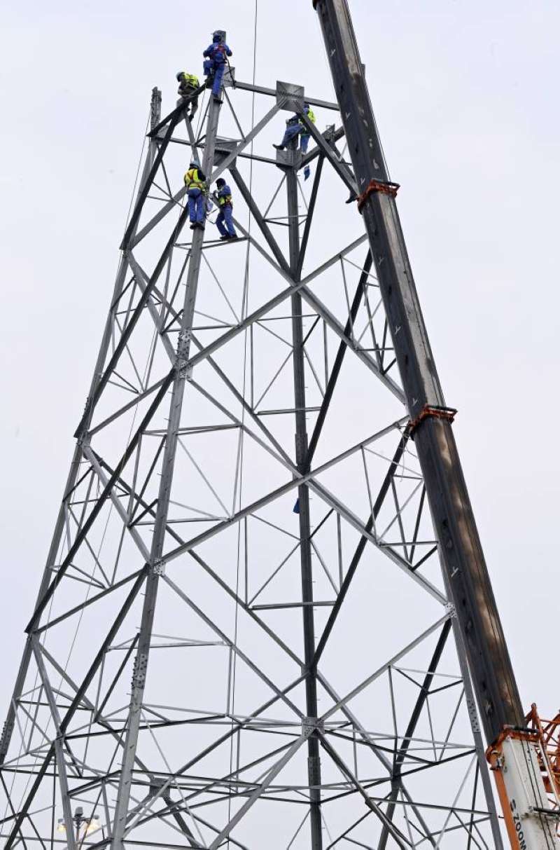 فك أحد أبراج خطوط الضغط العالي لترحيله عن مسار مشروع الجسر المقابل لـ«الأفنيوز» على الدائري الخامس (تصوير نايف العقلة)