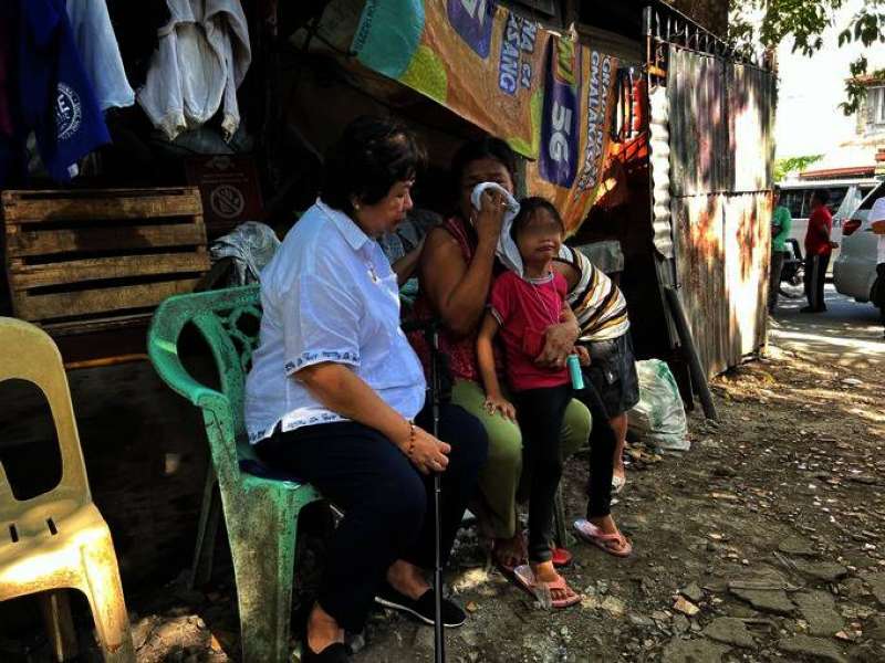 صورة نشرتها وسائل إعلام فيلبينية لوزيرة العمالة المهاجرة تواسي والدة العاملة التي وجدت جثتها في الكويت