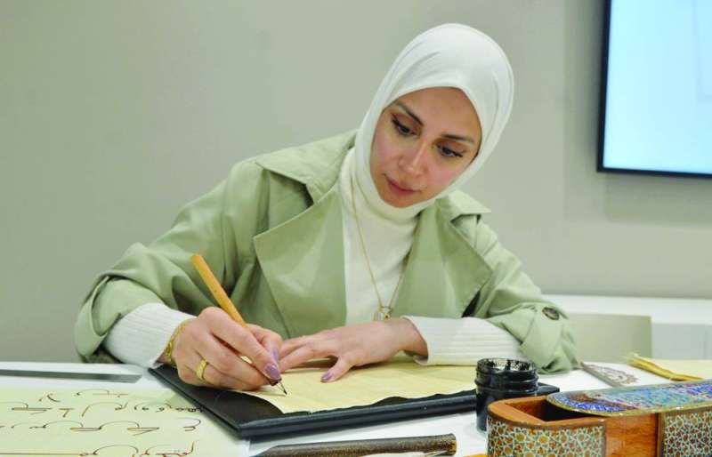 إحدى الطالبات ترسم العبارة خلال المسابقة