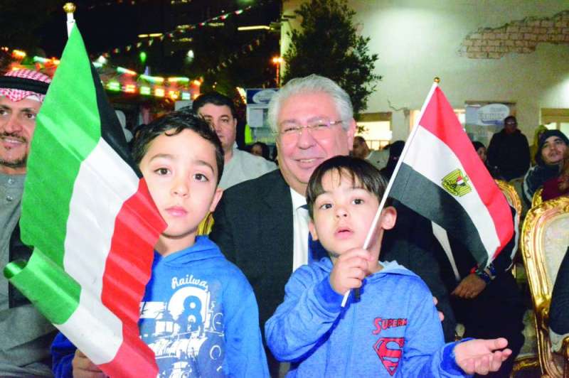 
السفير شلتوت مع طفلين يرفعان علمي الكويت ومصر