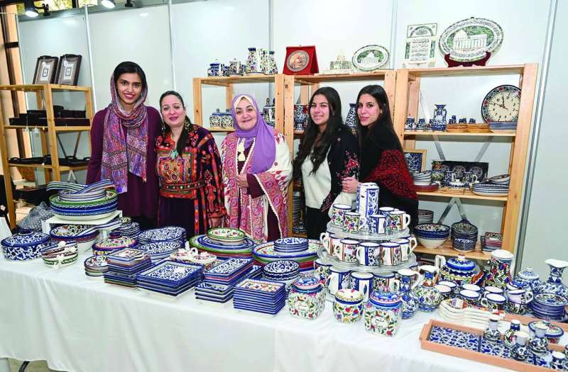 
فتيات فلسطينيات مع نائبة السفير الباكستاني أمام مشغولات يدوية	 (أسعد عبدالله)
