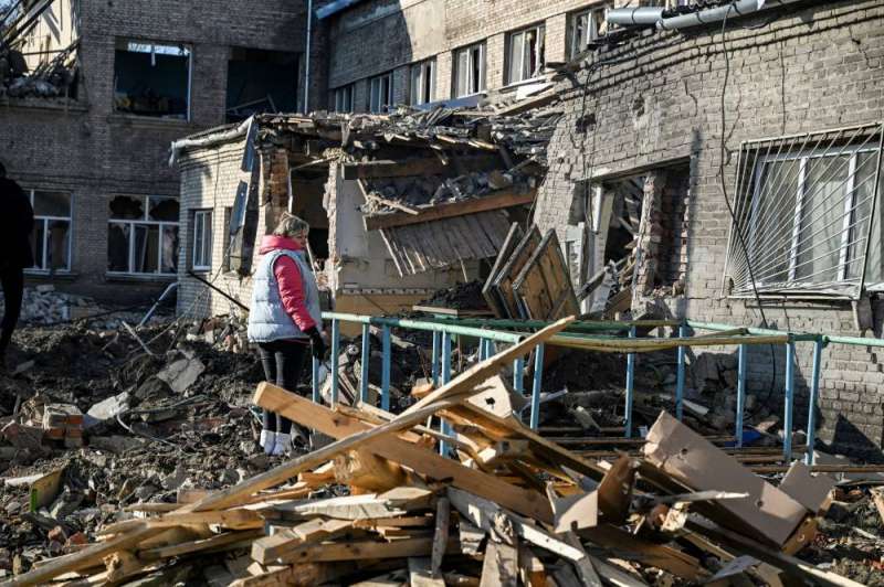 امرأة تقف فوق أنقاض مدرسة مُدمرة في شرق أوكرانيا (أ ف ب)