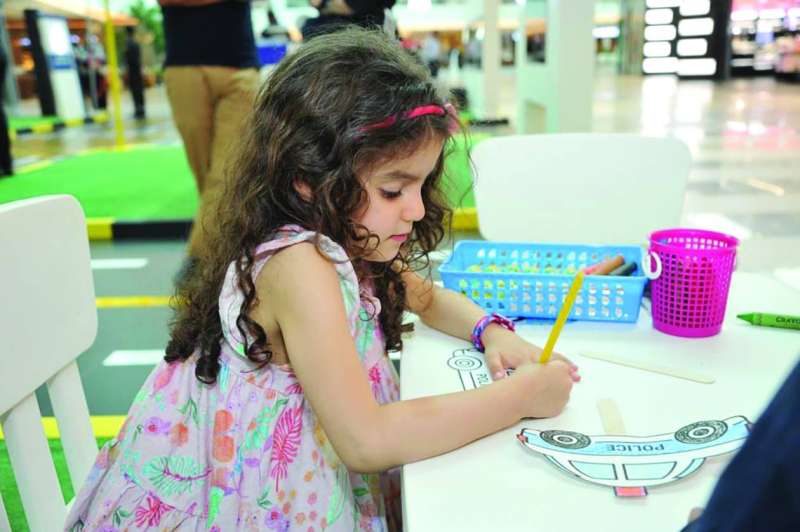 
طفلة تمارس هوايتها بالرسم في ركن الأطفال