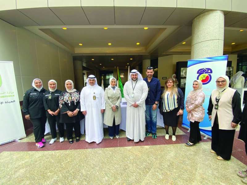 عبدالله المشعل مُتوسّطاً منتسبي «الدفاع» المشاركين في المعرض