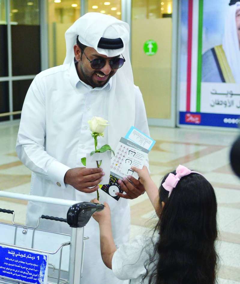 طفلة تُقدّم وردة وبروشورات مرورية لأحد المسافرين 