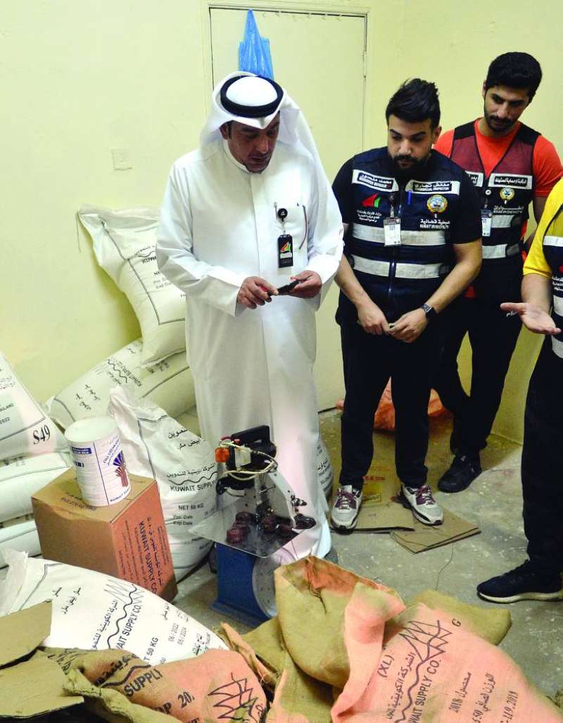 معاينة المواد التموينية التي يتم تفريغها وتوزيعها	(تصوير سعود سالم)
