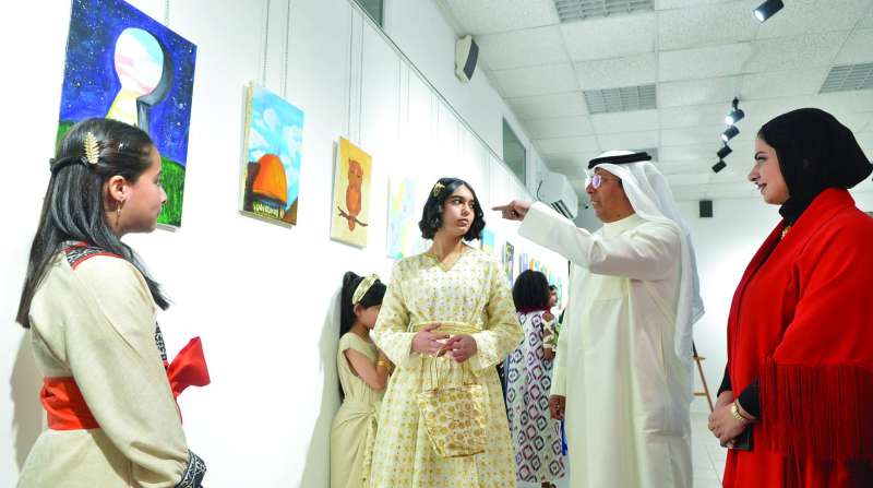 محمد ثلاب يستمع لشرح طفلة عن رسمتها	 (تصوير سعود سالم) 