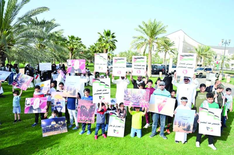 
كبار وصغار يحملون لافتات التضامن