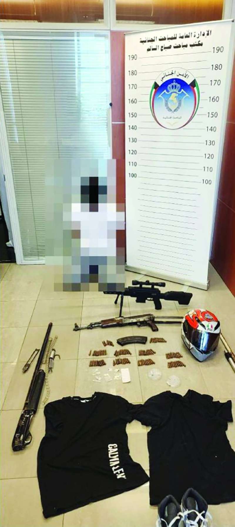 المتهم وأمامه المضبوطات
