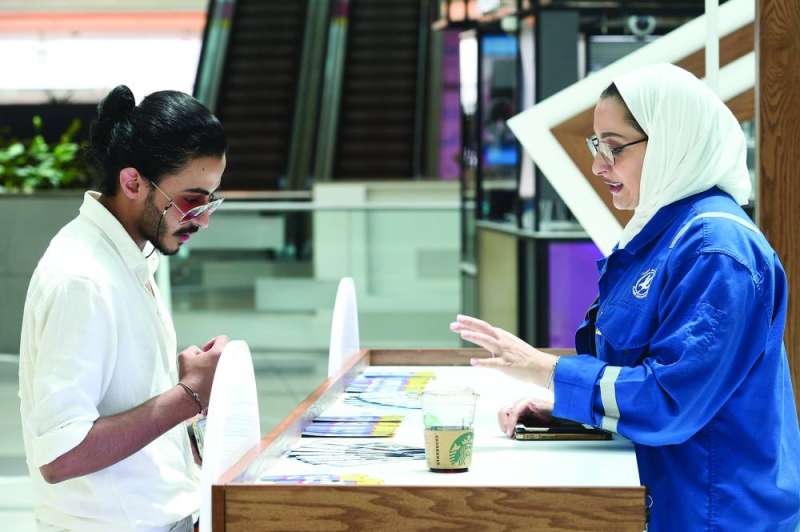 موظفة من نفط الكويت تشرح لأحد الشباب طبيعة الحملة