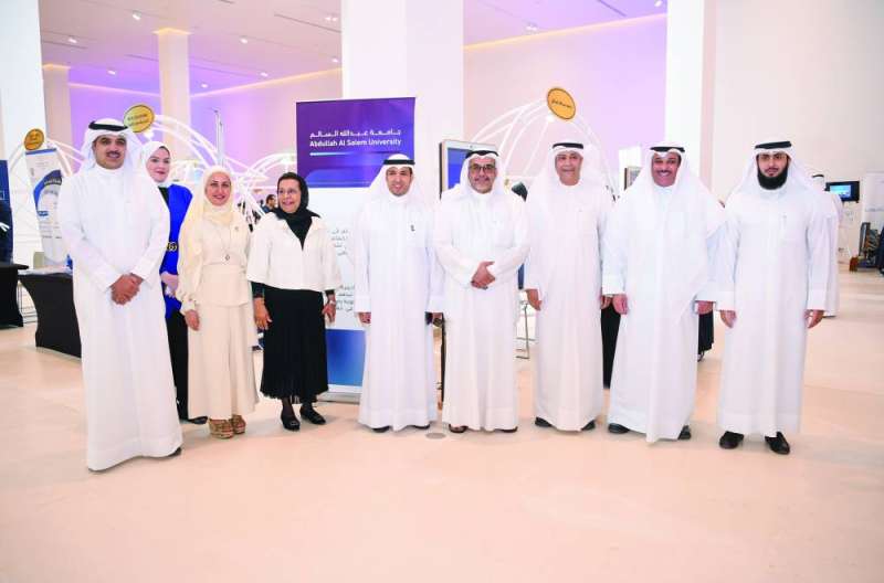 
مدير جامعة الكويت والحمود يتوسطان مسؤولين أمام ركن جامعة عبدالله السالم في المعرض