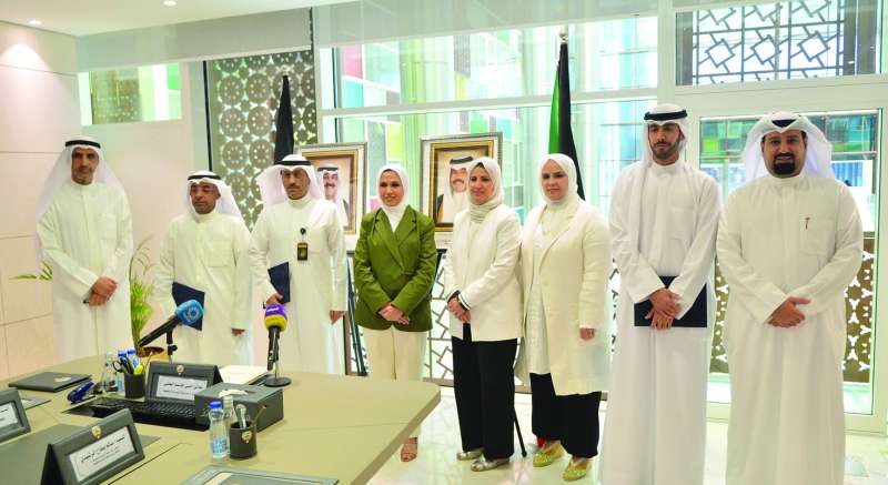 
البغلي تتوسط ممثلي هيئة القوى العاملة واتحاد الجمعيات بعد توقيع المذكرة		 (تصوير سعود سالم)
