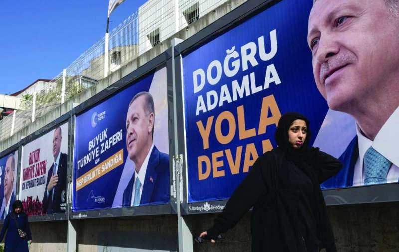 سيدتان تركيتان تمرّان بالقرب من لوحات انتخابية لأردوغان في إسطنبول	 (رويترز) 