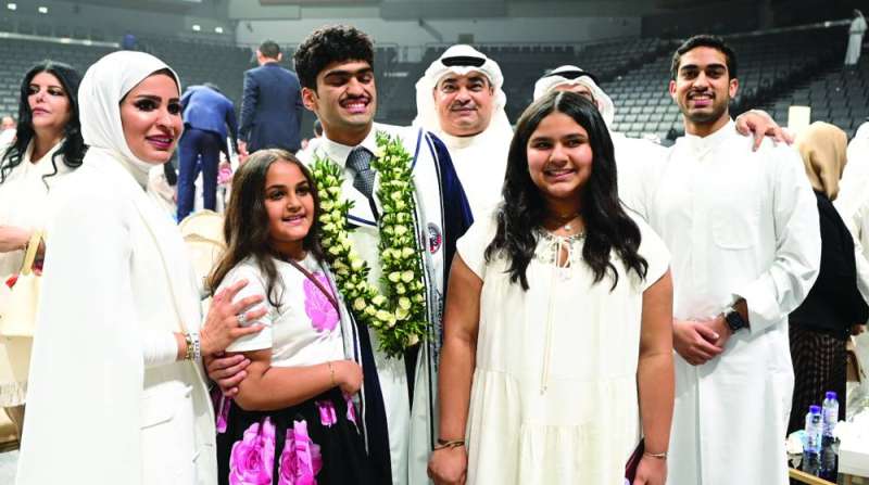 
أحد الخريجين مكللاً بالورود متوسطاً أسرته