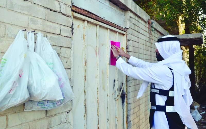 
لصق إنذار على أحد المساكن المخالفة