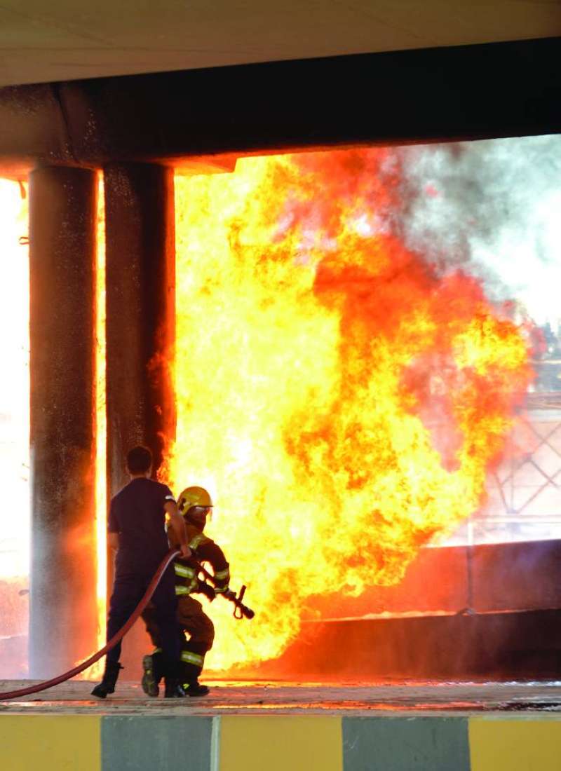 إطفائيان يتعاملان مع الحريق أسفل الجسر	(تصوير سعود سالم)