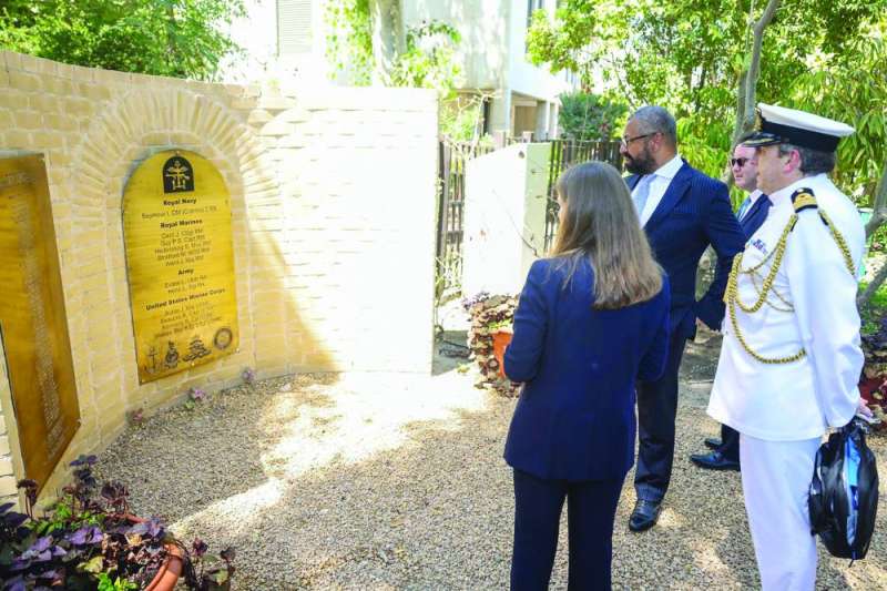 
وزير الخارجية جيمس كليفرلي ولويس والملحق العسكري بول مولفيني أمام نصب القتلى البريطانيين في حرم السفارة البريطانية