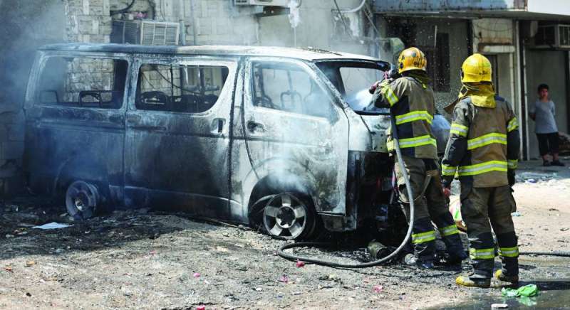 إطفائيان يبرّدان أحد الباصين 	(تصوير سعود سالم) 
