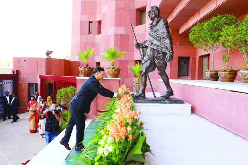 
السفير واضعاً إكليلاً من الزهور على تمثال المهاتما غاندي
