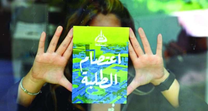 
طالبة تضع ملصقاً على الزجاج 