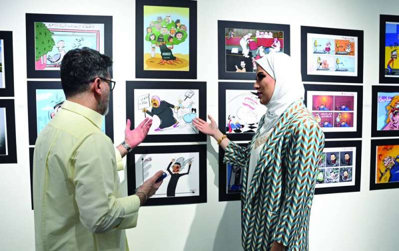 الزميلة سارة النومس تشرح فكرة إحدى لوحاتها 