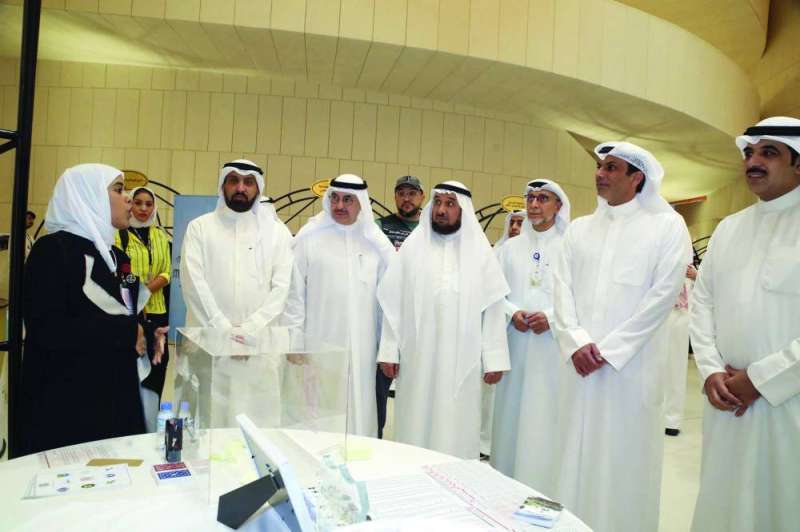 العيبان والظفيري والسليماني خلال جولة على المعرض المرافق للملتقى 