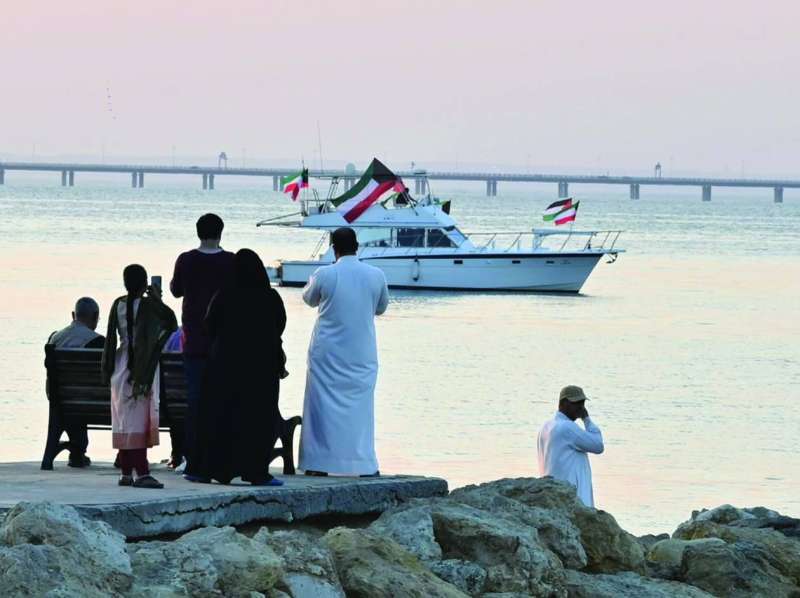 قارب يرفع العلمين الكويتي والفلسطيني قبالة ساحة الإرادة