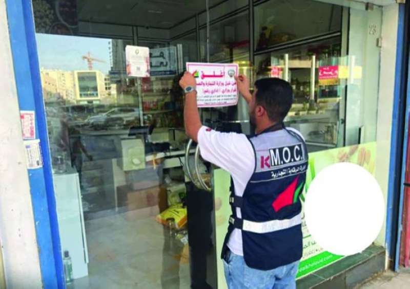 أحد مفتشي «التجارة» يضع شارة الإغلاق على باب الشركة