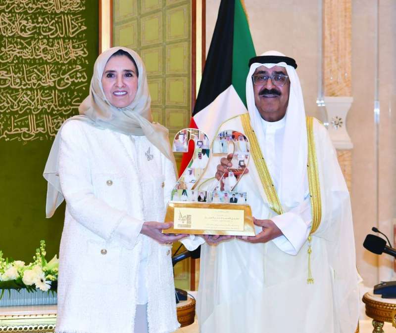 ولي العهد يتسلّم هدية تذكارية من الشيخة عايدة سالم العلي خلال حفل تكريم الفائزين بجائزة المعلوماتية في قصر بيان (مايو 2023)