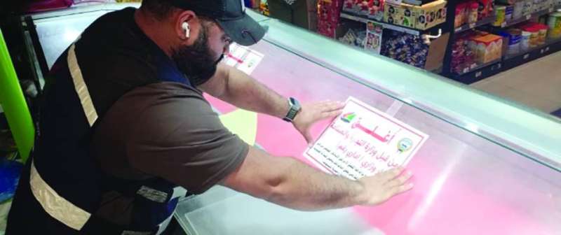 


أحد مفتشي «التجارة» يضع ملصق الإغلاق 