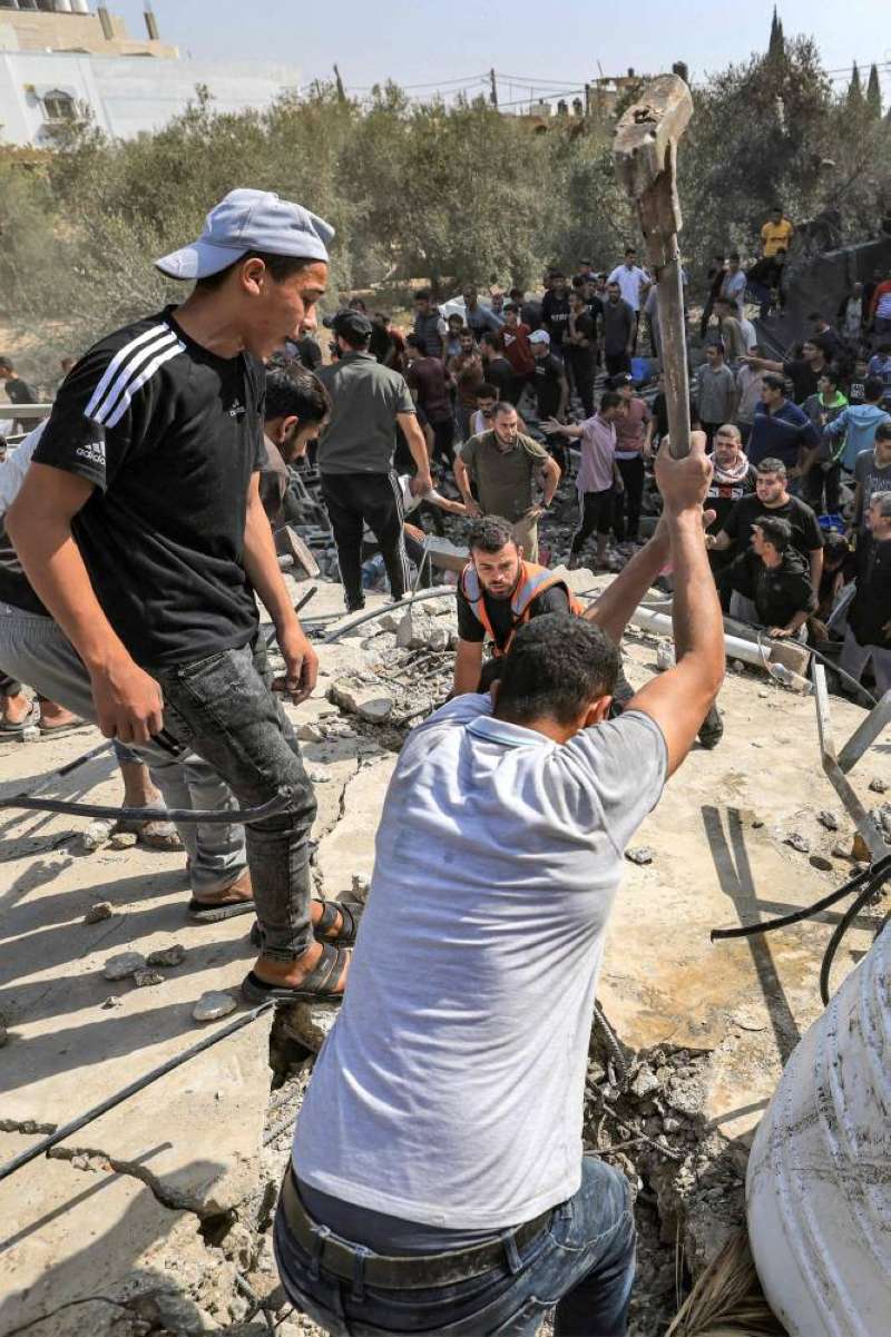 فلسطيني يستخدم مطرقة لثقب سطح مبنى دمرته غارات إسرائيلية بحثاً عن ناجين في غزة أمس (أ ف ب)