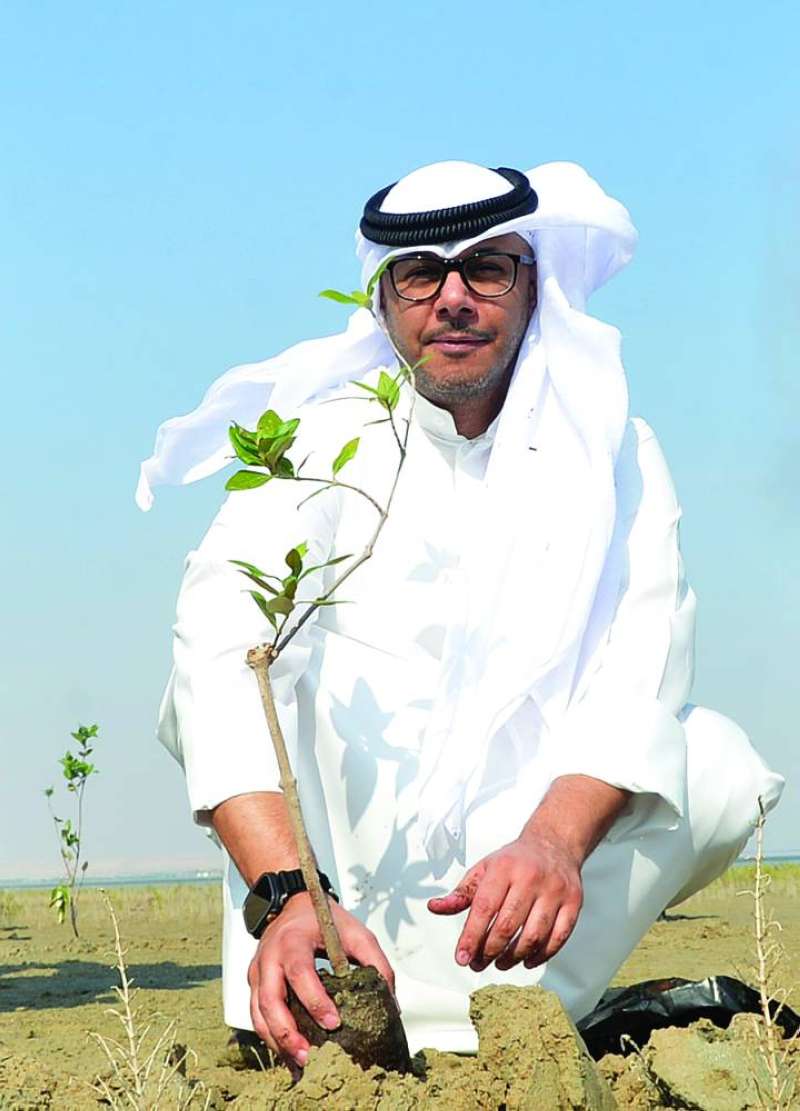 عبدالله الزيدان يزرع شتلة المانغروف	 (تصوير سعود سالم) 