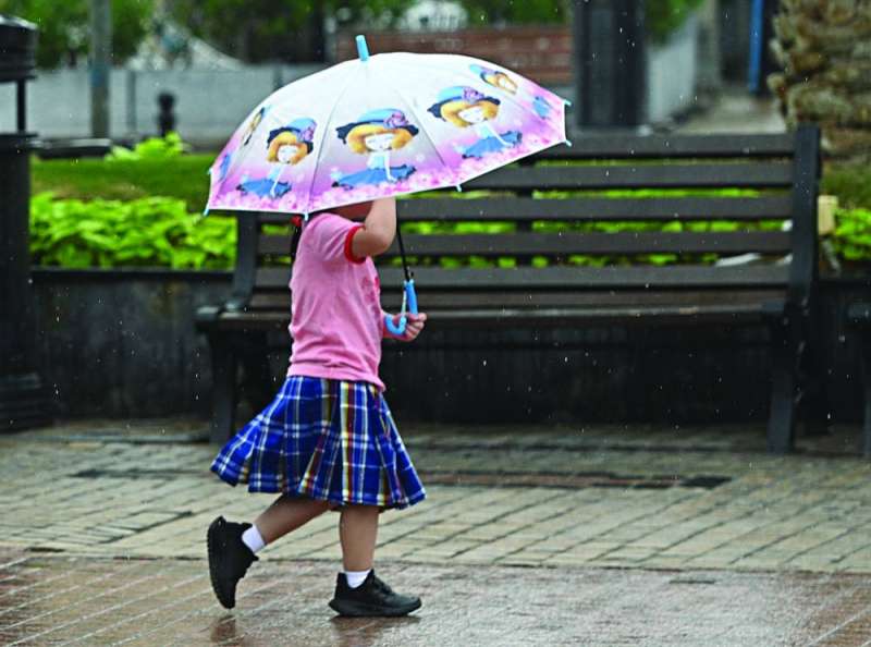 


طفلة تحتمي بمظلة 	(تصوير نايف العقلة) 