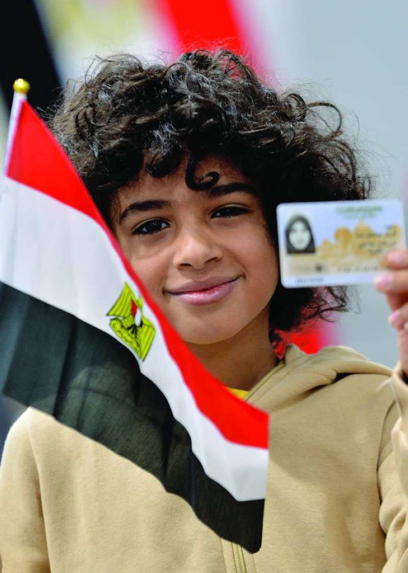 


طفل يحمل هوية أمه التي أدلت بصوتها 