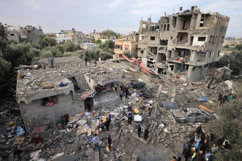 فلسطينيون يتفقدون الأضرار في مخيم المغازي للاجئين بعد غارة إسرائيلية (أ ف ب)