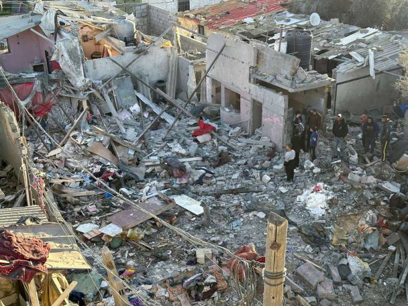 فلسطينيون يعاينون الدمار في مبنى استهدفته غارات إسرائيلية على رفح أمس (رويترز)