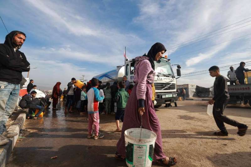 نازحون يتهافتون للحصول على الماء في رفح (أ ف ب)