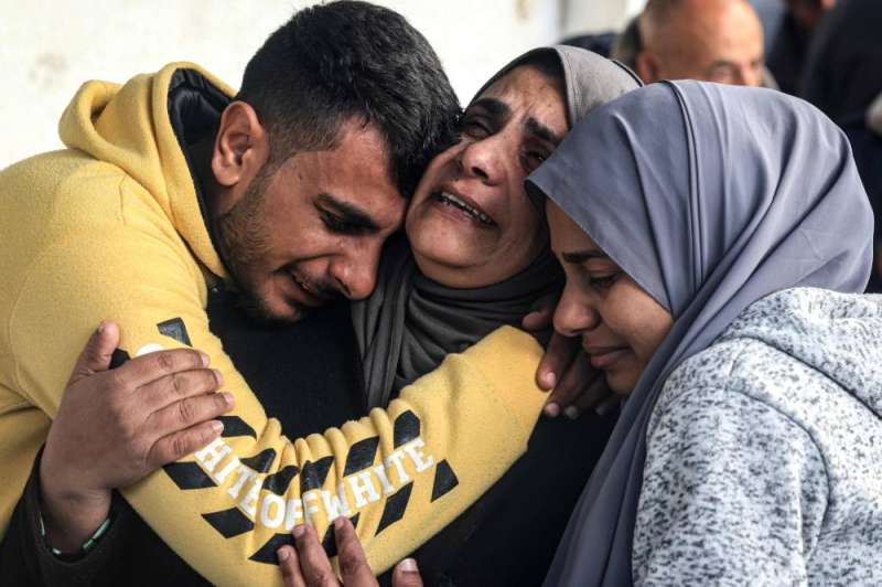 فلسطينيون يبكون أفراداً من عائلتهم سقطوا في الغارات الإسرائيلية (أ ف ب)