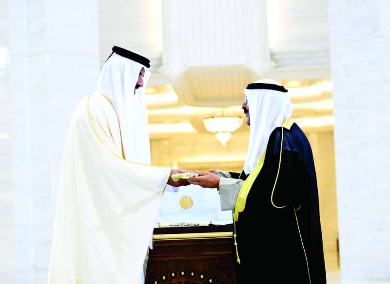 أمير قطر مقدماً لسمو الأمير أرفع الأوسمة القطرية 