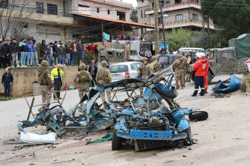 جنود لبنانيون أمام مركبة استهدفتها مُسيّرة إسرائيلية قرب بلدة الصويري في منطقة البقاع الغربي (أ ف ب)