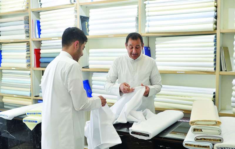 مواطن يبتاع قماشاً تمهيداً لطلب تفصيل الدشداشة