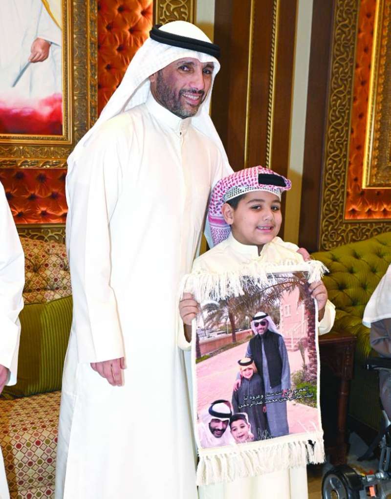 الغانم وأحد الأطفال خلال حفل الاستقبال 