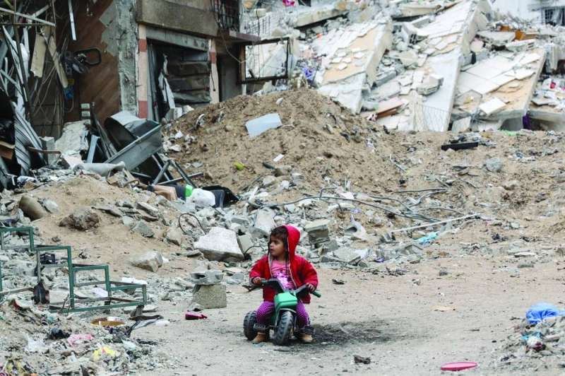 طفلة فلسطينية تلعب قرب مبنى مدمر في غزة (أ ف ب)