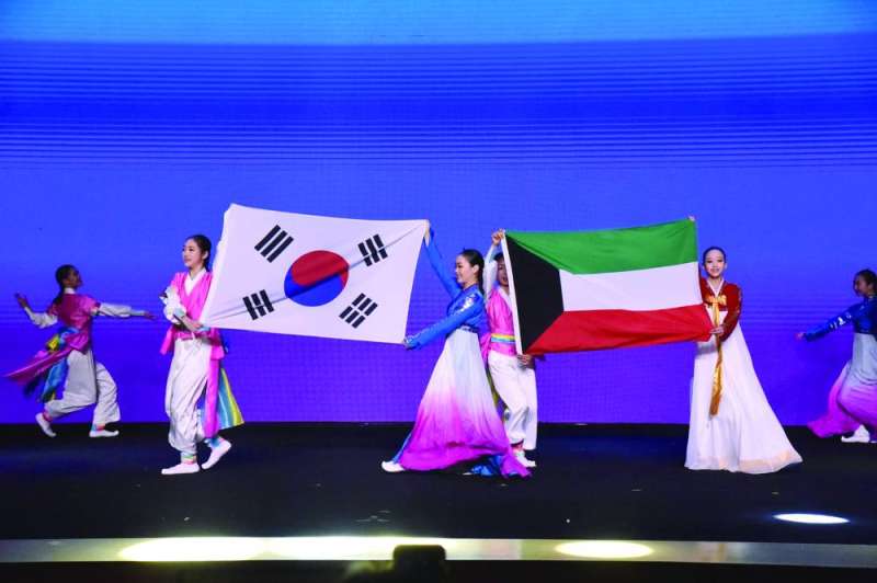 أعضاء الفرقة يحملون العلمين الكويتي والكوري على المسرح