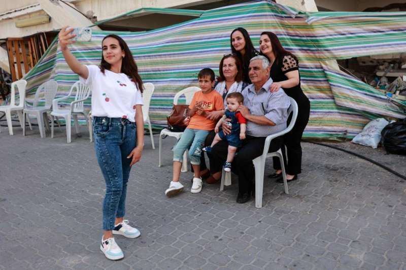 فتاة مسيحية تلتقط «سيلفي» مع عائلتها خلال احتفال الأرثوذكس بعيد الفصح في مدينة غزة (ا ف ب)