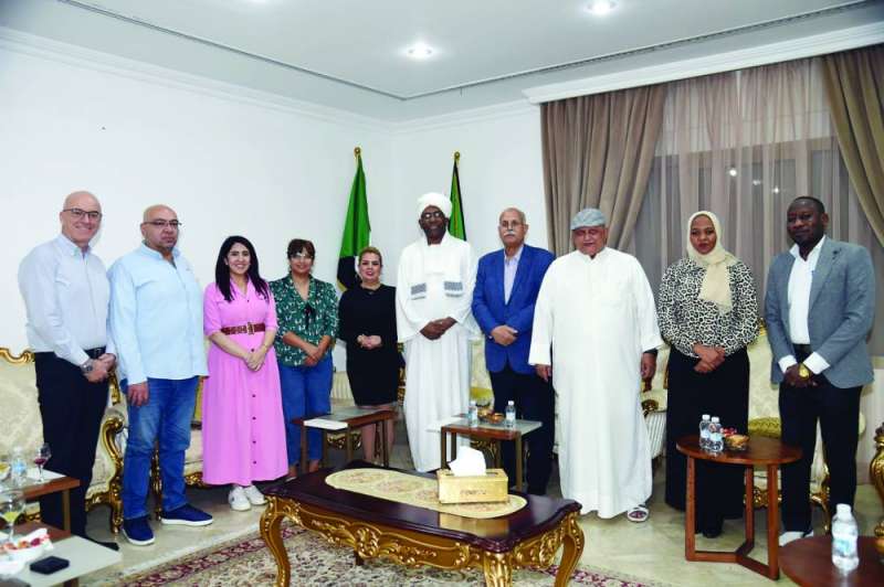 السفير السوداني متوسطاً ممثلي وسائل الإعلام