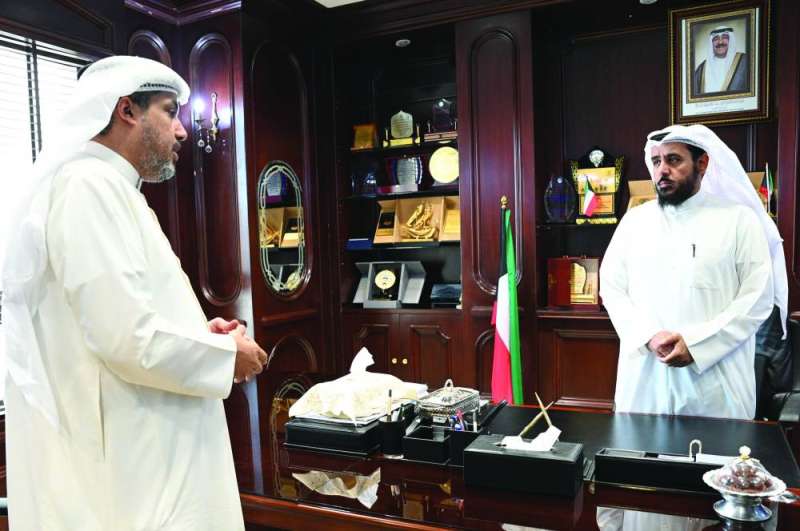 العتيبي يتحدث للزميل تركي المغامس على هامش استقبال المراجعين	 (تصوير نايف العقلة) 