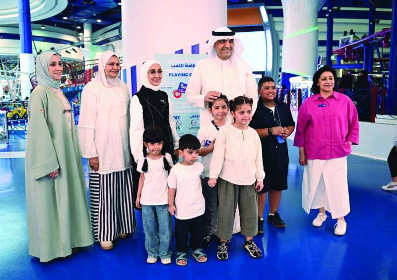 مدير عام الهيئة بالتكليف حمد البرجس مع عدد من الأطفال وأولياء أمورهم (تصوير نايف العقلة)