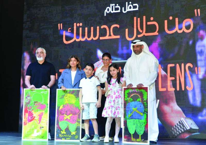 


أعضاء لجنة التحكيم خلال تسلّمهم لوحة «حنظلة» بحضور طفلين من غزة 